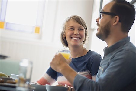 real people woman coffee - A couple sitting in a coffeeshop smiling and talking over a cup of coffee. Stock Photo - Premium Royalty-Free, Code: 6118-07353728