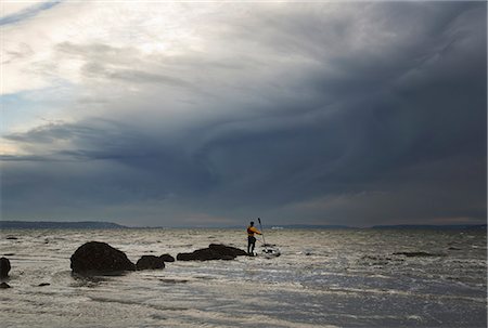 seattle - A man stands on a rock in the middle of the Puget Sound with his sea kayak floating next to him. Photographie de stock - Premium Libres de Droits, Code: 6118-07353840