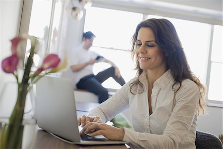 full body people sitting laptop - Couple at Home, Woman using Laptop and Man using Tablet Stock Photo - Premium Royalty-Free, Code: 6118-07353874