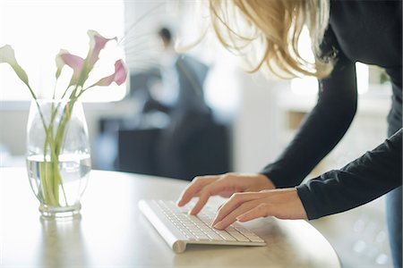 simsearch:878-07442523,k - Couple relaxing at home, woman using keyboard Photographie de stock - Premium Libres de Droits, Code: 6118-07353881