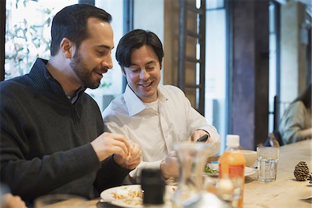 Men sharing text at restaurant table Photographie de stock - Premium Libres de Droits, Code: 6118-07353893