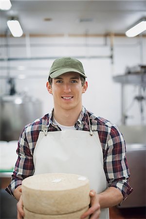 farmer - A small organic dairy farm with a mixed herd of cows and goats. Dairy building with large wheels of cheese maturing. Trays of produce. Stock Photo - Premium Royalty-Free, Code: 6118-07353916