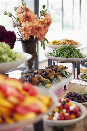 simsearch:6102-08952028,k - Organic prepared salads, vegetables and fruit on dishes, laid out for a party. A laden table. Flowers in a vase.  A farmstand food stall. Photographie de stock - Premium Libres de Droits, Code: 6118-07354054