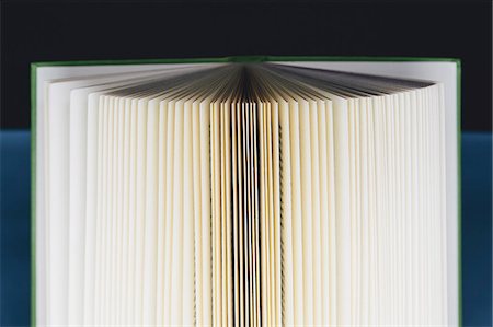 fanned out - A hard cover printed book, opened and upright. Pages fanned out with graduated yellowing edges, changing to brown and black in the centre. Stock Photo - Premium Royalty-Free, Code: 6118-07354058