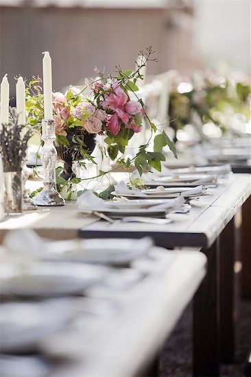 A formal wedding breakfast table, laid for a feast. Fresh flowers in the centre. Stock Photo - Premium Royalty-Free, Image code: 6118-07354128