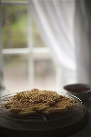 simsearch:6118-07353041,k - A dish of waffles on a tabletop. Net curtains draped back from a window. Foto de stock - Royalty Free Premium, Número: 6118-07354132