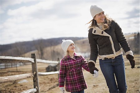 simsearch:6118-07354199,k - A woman and child walking along a path hand in hand on a farm in spring weather. Stock Photo - Premium Royalty-Free, Code: 6118-07354200