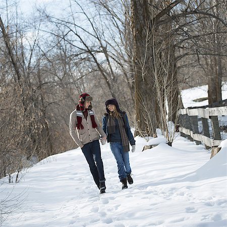 Winter scenery with snow on the ground. A couple walking hand in hand along a path. Stock Photo - Premium Royalty-Free, Code: 6118-07354470