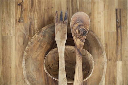 A wooden table top with two small turned bowls and two wooden salad servers. Wood grain and natural patterns. Stock Photo - Premium Royalty-Free, Code: 6118-07354488