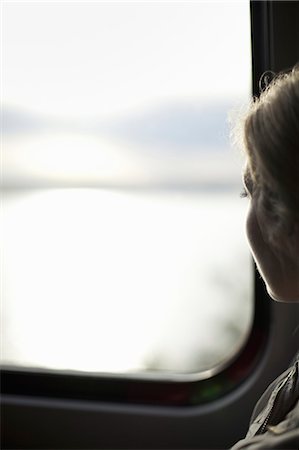 A woman sitting by a train window looking out at the view. Photographie de stock - Premium Libres de Droits, Code: 6118-07354491