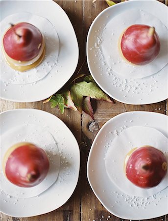 Tabletop viewed from above. Four plates with dessert. Pears dipped in sauce. Stock Photo - Premium Royalty-Free, Code: 6118-07354415