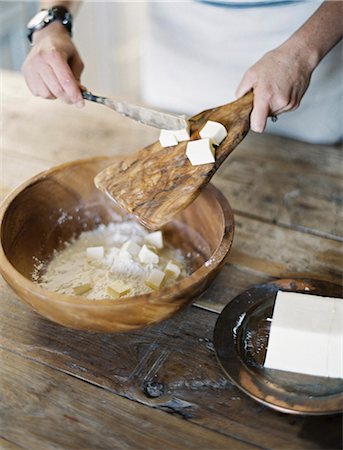 simsearch:6118-07352958,k - A domestic kitchen. A woman preparing a meal, mixing flour and fat to create pastry. Foto de stock - Sin royalties Premium, Código: 6118-07354425