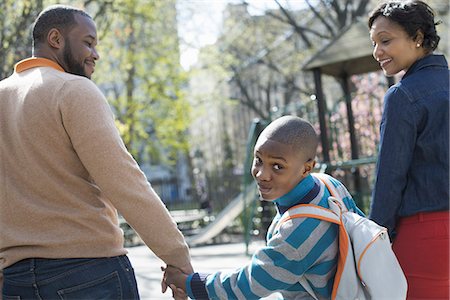 fathers - A New York city park in the spring. Sunshine and cherry blossom. A boy looking over his shoulder, between his parents. Photographie de stock - Premium Libres de Droits, Code: 6118-07354668