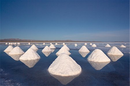 Piles of salt dry in the arid atmosphere of Bolivia's Salar de Uyuni. Fotografie stock - Premium Royalty-Free, Codice: 6118-07440124