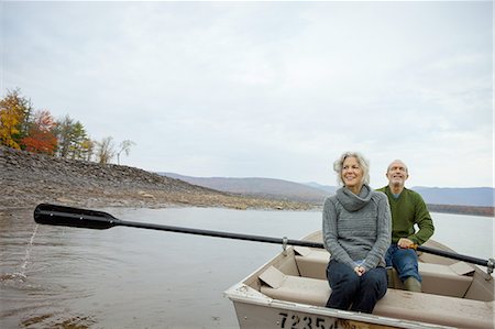 A couple, man and woman sitting in a rowing boat on the water on an autumn day. Photographie de stock - Premium Libres de Droits, Code: 6118-07440263