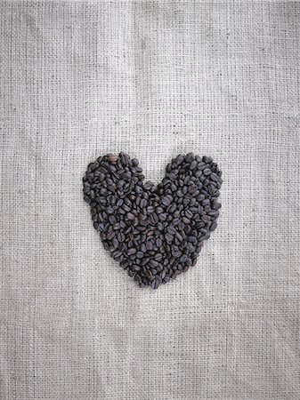 environmental conservation still life - Organic roasted coffee beans in a heart shape on a burlap sack. Stock Photo - Premium Royalty-Free, Code: 6118-07440284