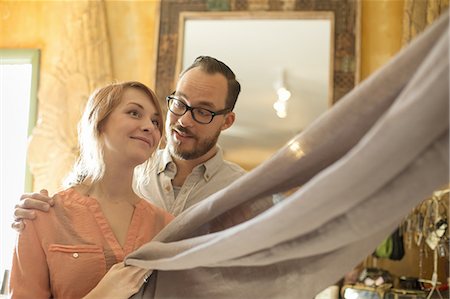 simsearch:6118-07439810,k - Two people, a couple running an antique store. Small business. Holding a piece of linen fabric. Stock Photo - Premium Royalty-Free, Code: 6118-07440350