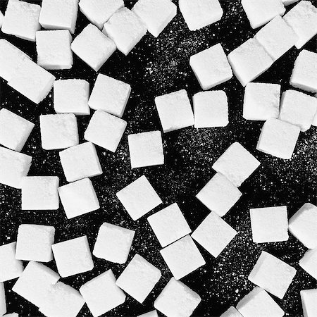 Overhead view of sugar cubes on black backdrop Foto de stock - Royalty Free Premium, Número: 6118-07440372