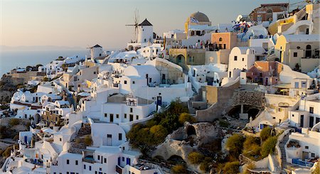 The windmills of Santorini in Greece. A hilltop town of whitewashed houses. Sunset. Foto de stock - Sin royalties Premium, Código: 6118-07440521