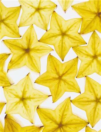 fruits bio - Slices of organic starfruit on white background Photographie de stock - Premium Libres de Droits, Code: 6118-07440665