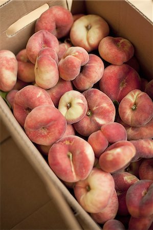 frutas biológicas - Fresh fruit on an organic farm stand. Doughnut peaches in a box. Foto de stock - Sin royalties Premium, Código: 6118-07440687