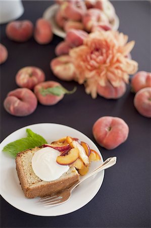 fruit vegetable dish - Fresh fruit and flowers. A slice of organic peach cake with a serving of creme fraiche and doughnut peaches. Photographie de stock - Premium Libres de Droits, Code: 6118-07440689