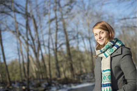 simsearch:6118-07354081,k - A young woman in a woodland on a winter day.  Wearing a bright knitted patterned scarf. Fotografie stock - Premium Royalty-Free, Codice: 6118-07440797