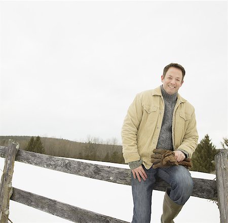 farmer sitting on the fence - A mature man in a barn coat Stock Photo - Premium Royalty-Free, Code: 6118-07440826