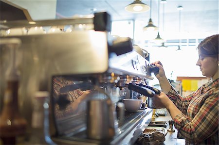 real people woman coffee - A person, barista making coffee, and frothing milk using a steam pipe, for a cappuccino. Coffee shop. Stock Photo - Premium Royalty-Free, Code: 6118-07439814