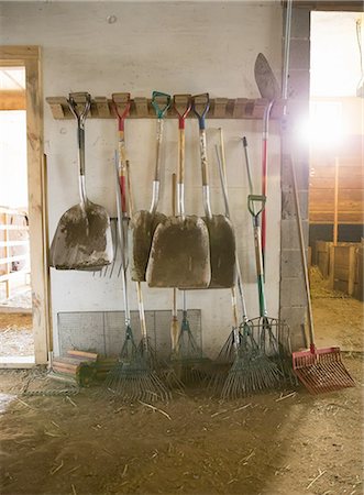 simsearch:6118-07203326,k - An organic farm. Livestock shed. Rack of shovels, hay rakes and a bootscraper. Photographie de stock - Premium Libres de Droits, Code: 6118-07439824