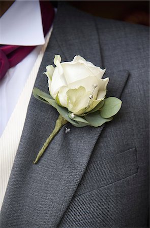 A groom in a grey jacket and white shirt, with a white rose boutonniere, in his buttonhole. Foto de stock - Sin royalties Premium, Código: 6118-07521747