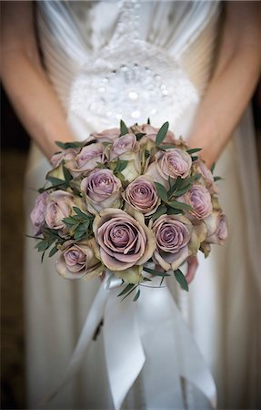 simsearch:6118-07521749,k - A bride in a white dress, holding a bridal bouquet of pastel coloured roses. Photographie de stock - Premium Libres de Droits, Code: 6118-07521744