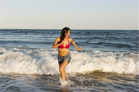 A beautiful young women at the water's edge on the beach in Atlantic City. Stock Photo - Premium Royalty-Free, Code: 6118-07521789
