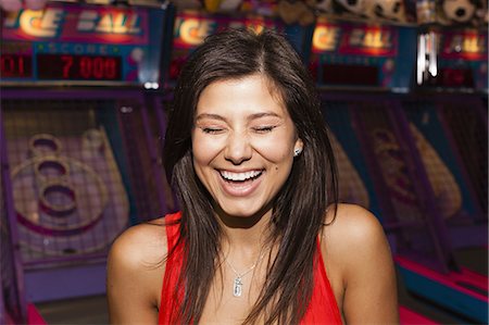 A beautiful young woman on the boardwalk in Atlantic City, in front of a row of slot machines. Foto de stock - Royalty Free Premium, Número: 6118-07521790