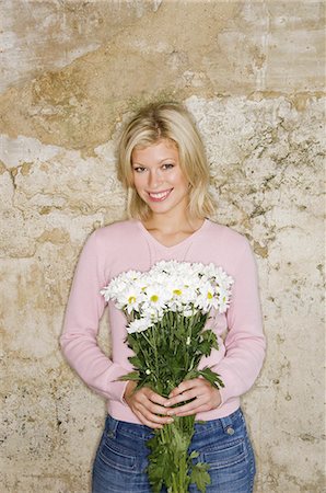 simsearch:6118-07521749,k - A young woman holding a bunch of daisies. Photographie de stock - Premium Libres de Droits, Code: 6118-07521829