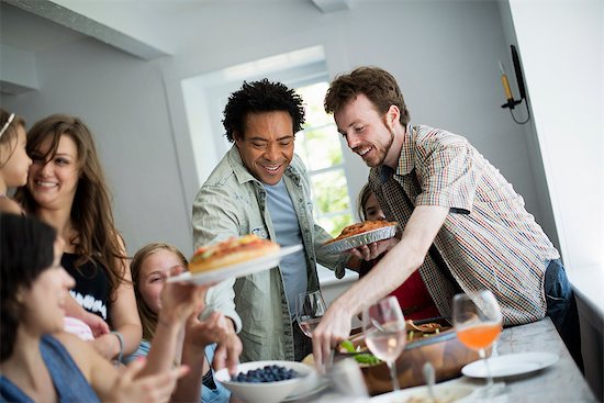 A family gathering for a meal. Adults and children around a table. Photographie de stock - Premium Libres de Droits, Le code de l’image : 6118-07769547