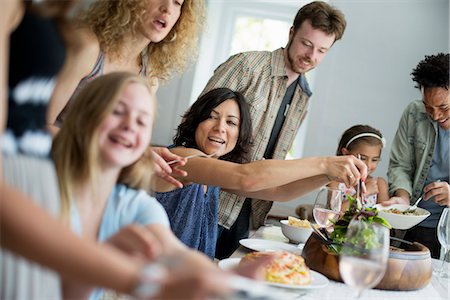 A family gathering for a meal. Adults and children around a table. Foto de stock - Sin royalties Premium, Código: 6118-07769544