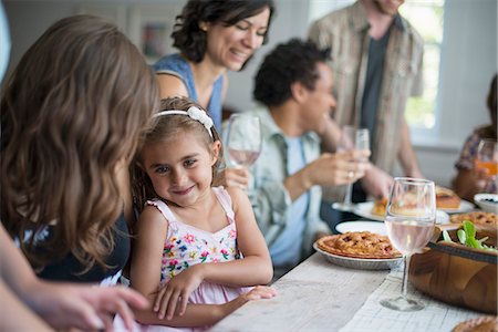 simsearch:6118-07769553,k - A family gathering for a meal. Adults and children around a table. Stock Photo - Premium Royalty-Free, Code: 6118-07769550