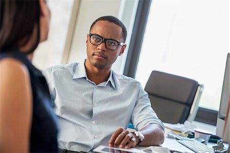 A man and woman talking in an office. Stock Photo - Premium Royalty-Free, Code: 6118-07781689