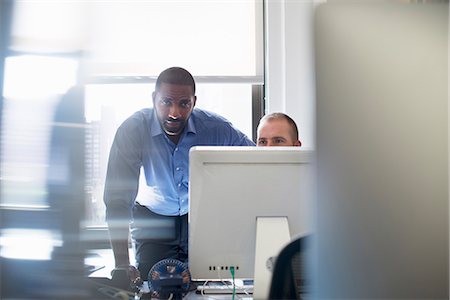 Two men working in an office, both looking at a computer monitor. Photographie de stock - Premium Libres de Droits, Code: 6118-07781639