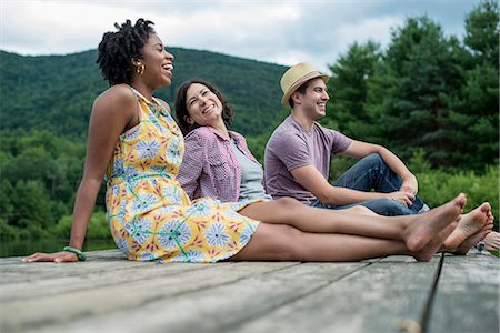 simsearch:6118-07781736,k - A group of people sitting on a woode pier overlooking a lake. Stockbilder - Premium RF Lizenzfrei, Bildnummer: 6118-07781743