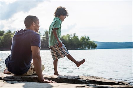 A father and son on a lake shore in summer. Photographie de stock - Premium Libres de Droits, Code: 6118-07781758