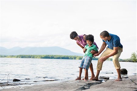 simsearch:6118-07781841,k - A family, mother, father and son playing on the shores of a lake. Stock Photo - Premium Royalty-Free, Code: 6118-07781782