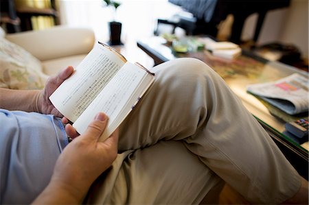 Man sitting on sofa reading a book. Photographie de stock - Premium Libres de Droits, Code: 6118-07781790
