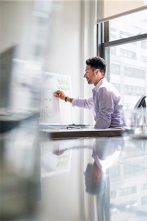 simsearch:6118-07769527,k - Office life. A man working on a wall chart in his office. Photographie de stock - Premium Libres de Droits, Code: 6118-07781708