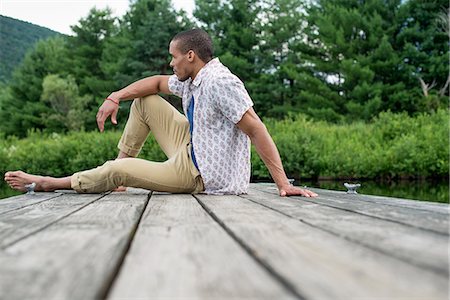 simsearch:6118-07781736,k - A man sitting on a wooden pier by a lake in summer Stockbilder - Premium RF Lizenzfrei, Bildnummer: 6118-07781738