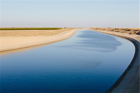 Irrigation canal serving drought-ridden agricultural areas of Central Valley, California. Stock Photo - Premium Royalty-Free, Code: 6118-07731763