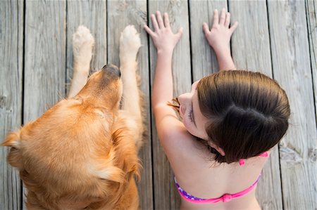 ethnic preteens swimwear girls - A young girl and a golden retriever dog side by side on a jetty. Photographie de stock - Premium Libres de Droits, Code: 6118-07731786