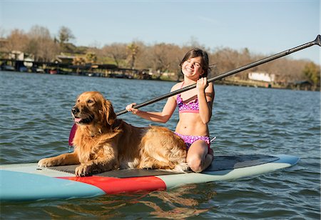 remo (instrumento) - A child and a retriever dog on a paddleboard on the water. Foto de stock - Sin royalties Premium, Código: 6118-07731793