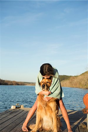 A girl cuddling a golden retriever dog. Photographie de stock - Premium Libres de Droits, Code: 6118-07731804